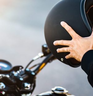 Motorcycle couple holding helmets in hands .