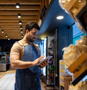 Retail clerk working at a food store and doing the inventory - small business concepts