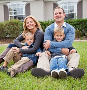 Family with two boys (4 and 6 years) sitting outside home.