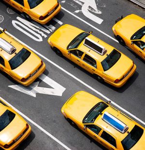Fleet of yellow taxi cabs make their way down the street of Broadway in New York City in view from above